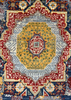 A close-up of a traditional patterned rug with a central medallion design in yellow, red, blue, gray, and cream.