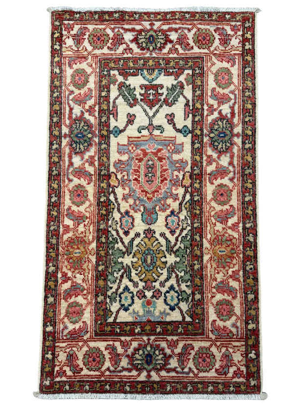 A rectangular traditional oriental rug with a cream center field, red borders, and multicolored floral motifs, photographed flat against a gray background.