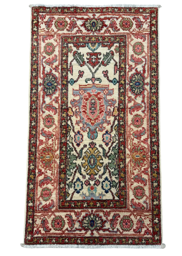 A rectangular traditional oriental rug with a cream center field, red borders, and multicolored floral motifs, photographed flat against a gray background.