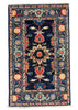 A rectangular traditional area rug with a dark navy blue center and ornate floral motifs in red, beige, and light blue, laid flat on a gray concrete floor.
